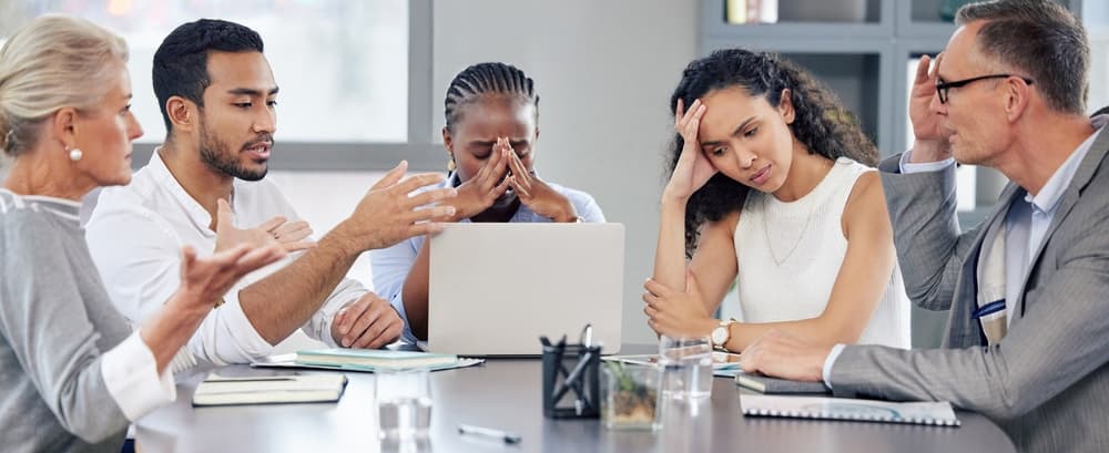 A team feeling stressed and overwhelmed in a meeting